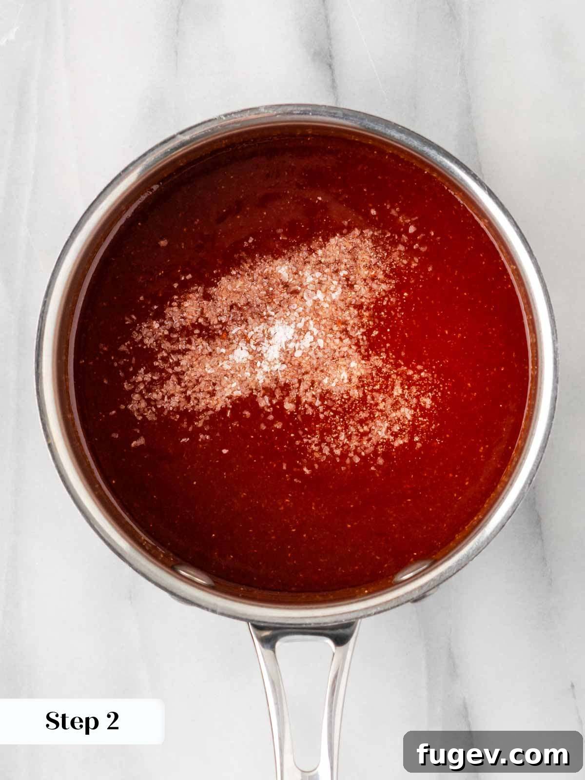 Simple Homemade BBQ Sauce 6 A hand adding salt to the simmering homemade BBQ sauce.