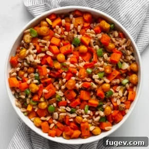 Farro with tender roasted carrots and chickpeas in a serving bowl.