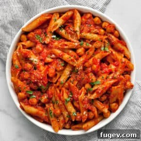Pasta with chickpeas and spicy tomato sauce in a bowl.