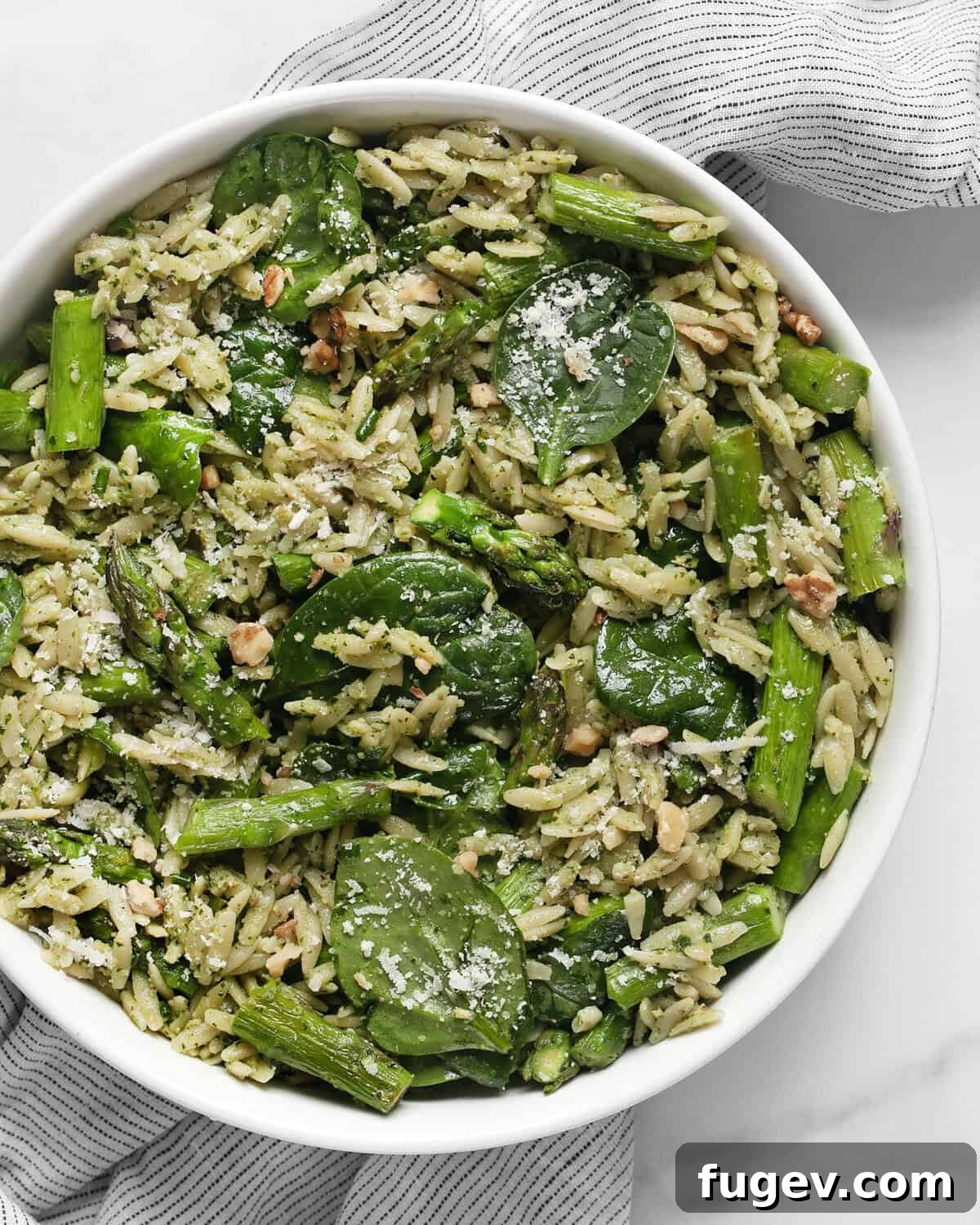 Vibrant Spinach Pesto Orzo with Roasted Asparagus 2 A beautifully presented bowl of Spinach pesto orzo with roasted asparagus, garnished with fresh herbs and Parmesan.
