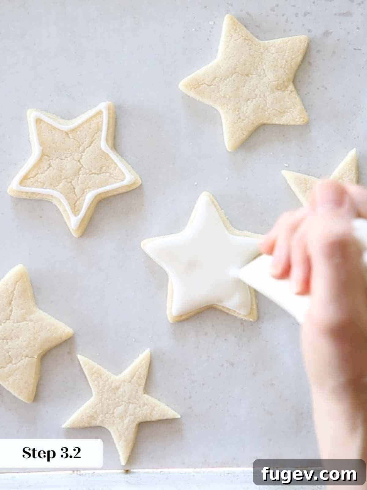 Melt-in-Your-Mouth Sugar Cookies 14 Flooding white royal icing to fill the outlined star-shaped sugar cookies.