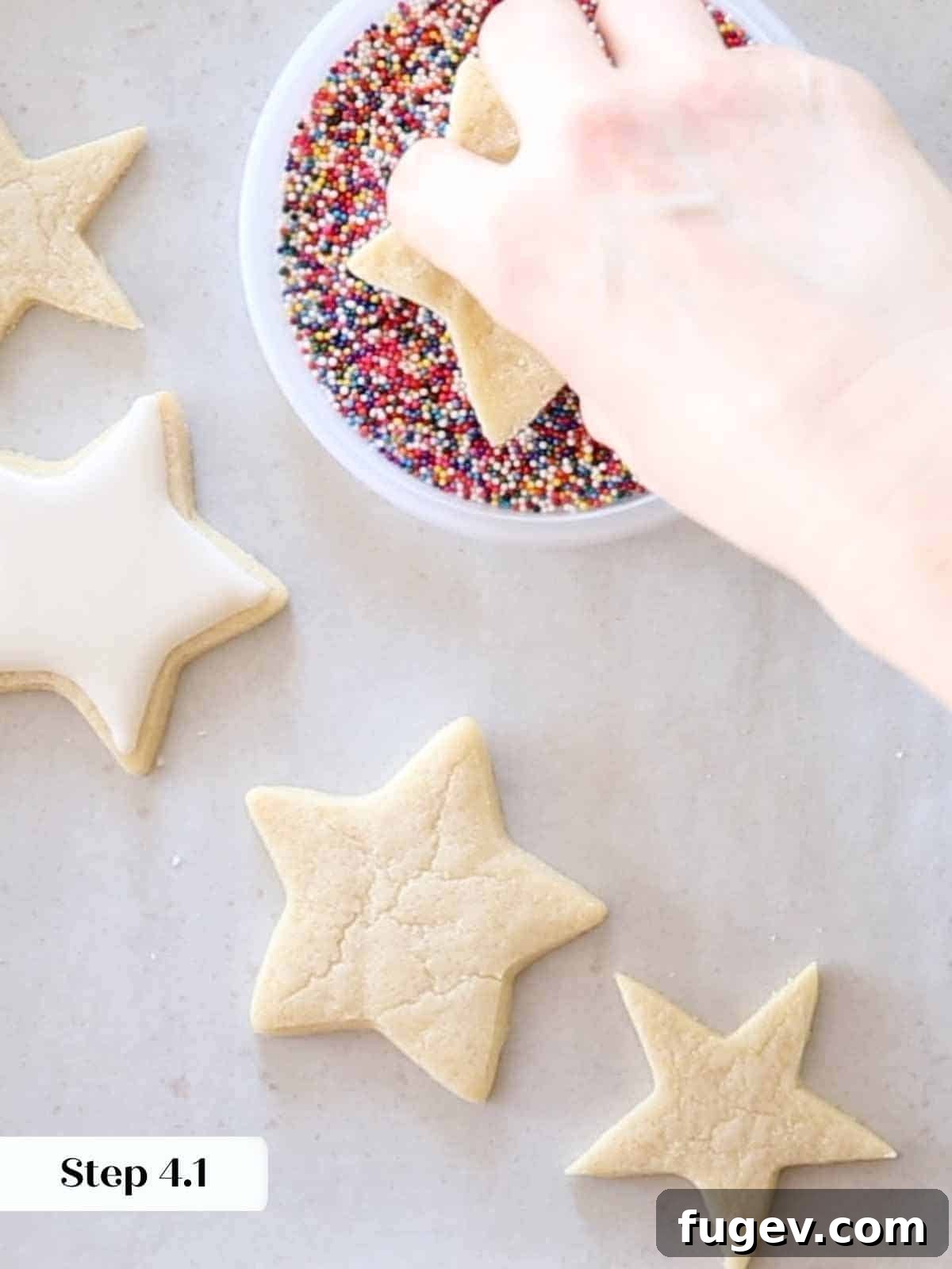 Melt-in-Your-Mouth Sugar Cookies 15 Dipping an iced cookie into rainbow jimmies (sprinkles).
