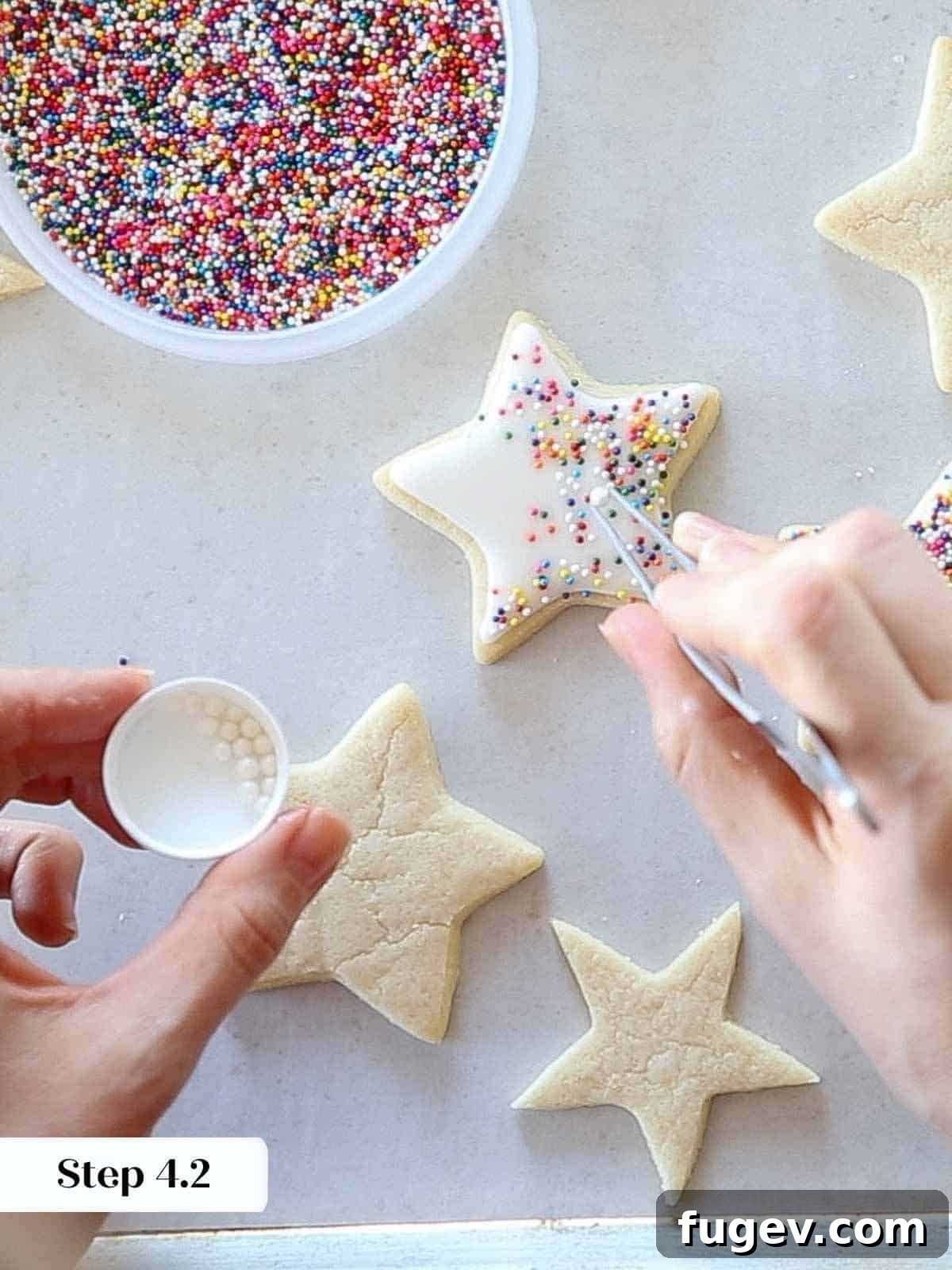 Melt-in-Your-Mouth Sugar Cookies 16 Adding rainbow jimmies and sugar pearls to an iced cookie with tweezers.