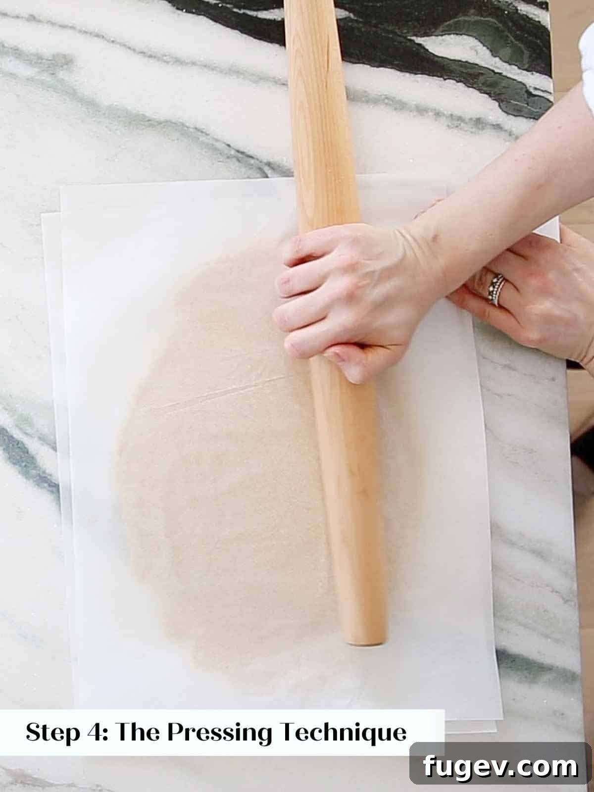Melt-in-Your-Mouth Sugar Cookies 9 Pressing dough with a rolling pin to smooth and flatten it between parchment.