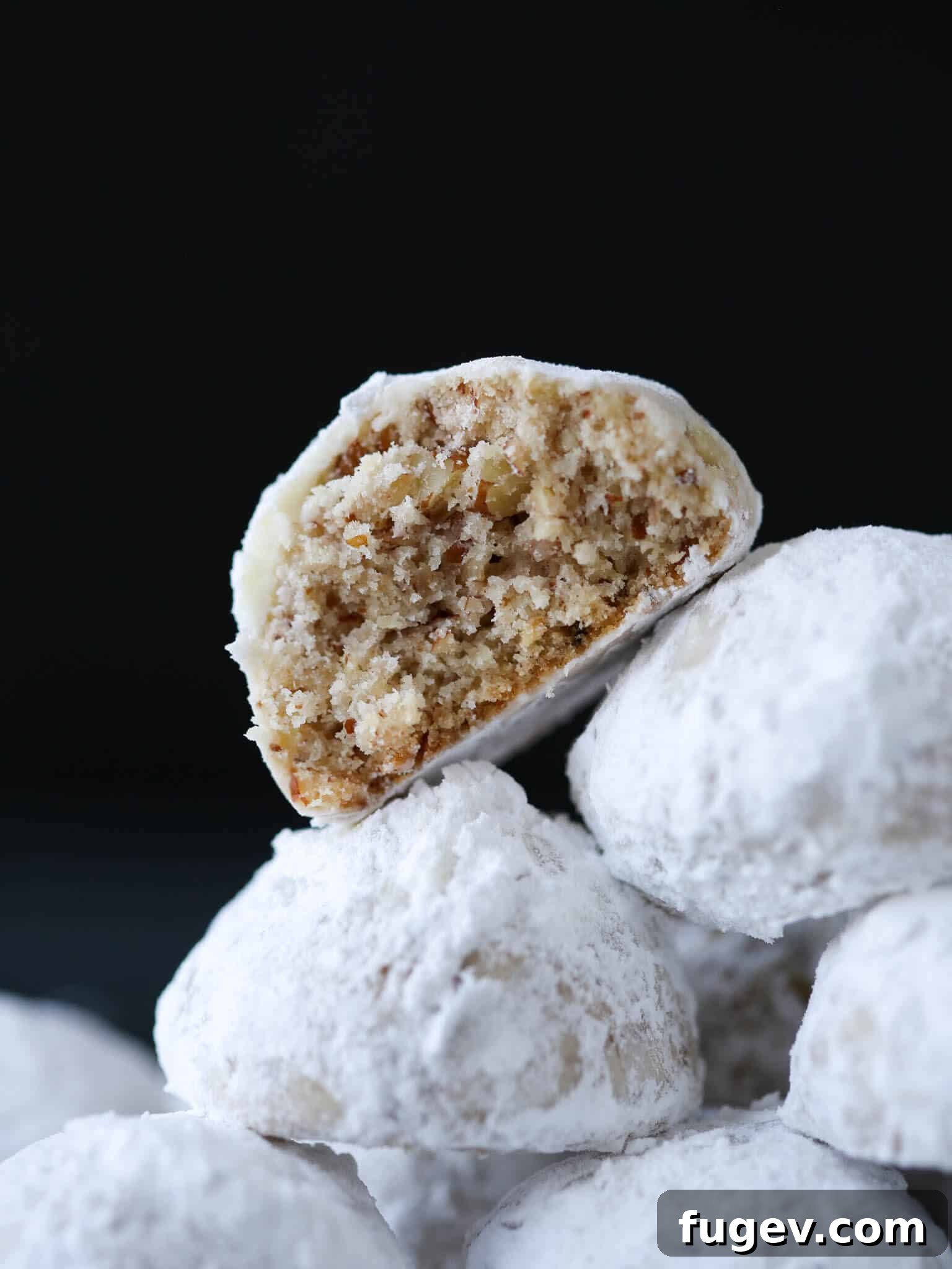 25 Deliciously Simple Christmas Cookies 14 Pecan Snowball Cookies stacked cut open.