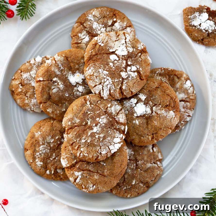 25 Deliciously Simple Christmas Cookies 40 stacked gingerbread crinkle cookies on white plate.