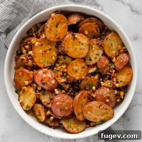 Roasted red potato salad, featuring crispy potatoes and corn dressed in a fresh herb vinaigrette.