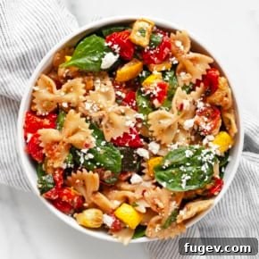 Roasted vegetable bow tie pasta salad, a colorful dish with zucchini, squash, bell peppers, and tomatoes.