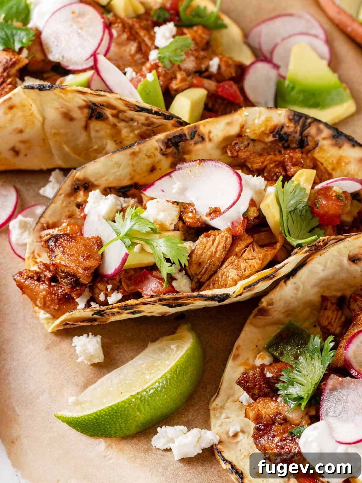 Fiesta Chicken Tacos 2 Flavorful chopped chicken tacos with a fresh lime wedge and cilantro.