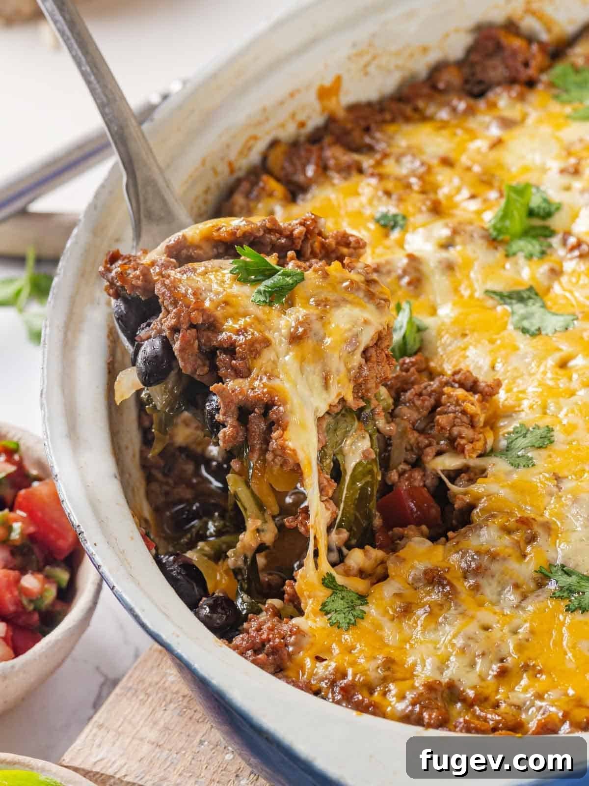 Cheesy Taco Bake 2 Taco bake being served with a gooey cheese pull, highlighting the delicious layers.