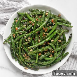 Grilled green beans with almond gremolata on a plate.