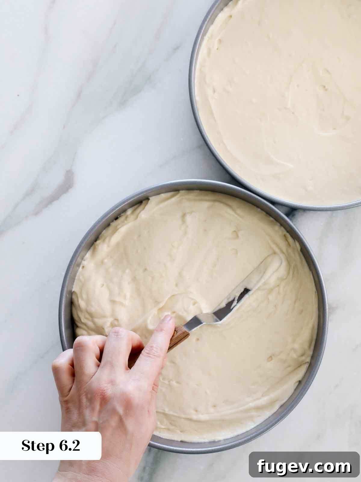 Velvet Vanilla Cake Recipe 15 Smoothing cake batter evenly into pans with an offset spatula for level baking.