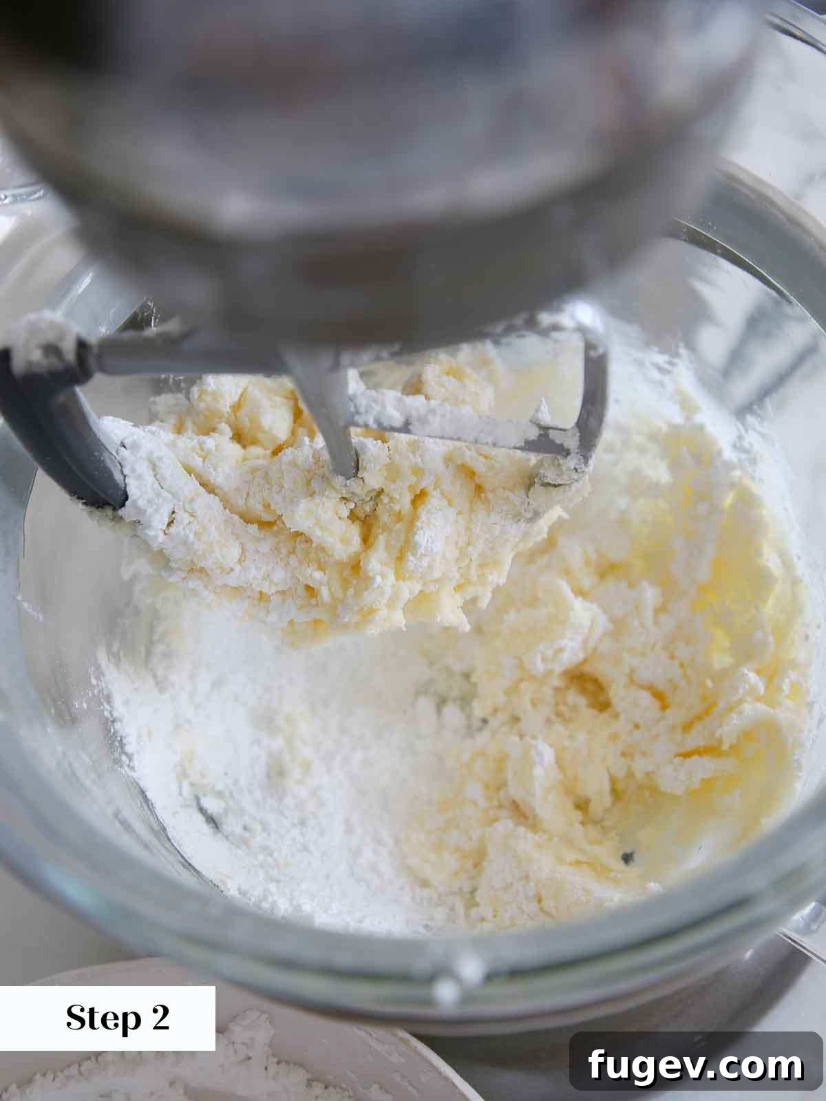 Velvet Vanilla Cake Recipe 17 Mixing powdered sugar into softened butter for vanilla buttercream frosting.
