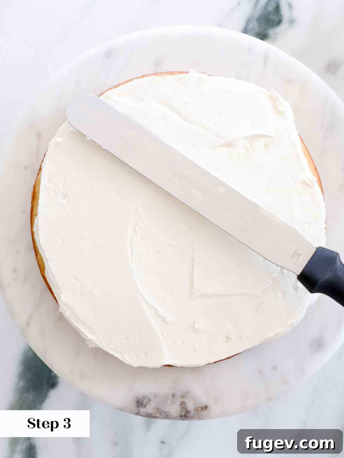Velvet Vanilla Cake Recipe 22 The process of smoothing out buttercream between cake layers for a neat finish.