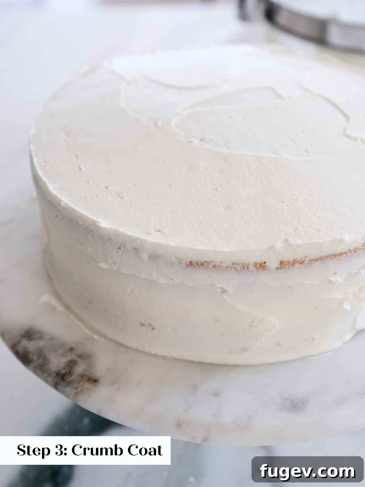 Velvet Vanilla Cake Recipe 23 The initial crumb coat applied to a vanilla cake, locking in loose crumbs.