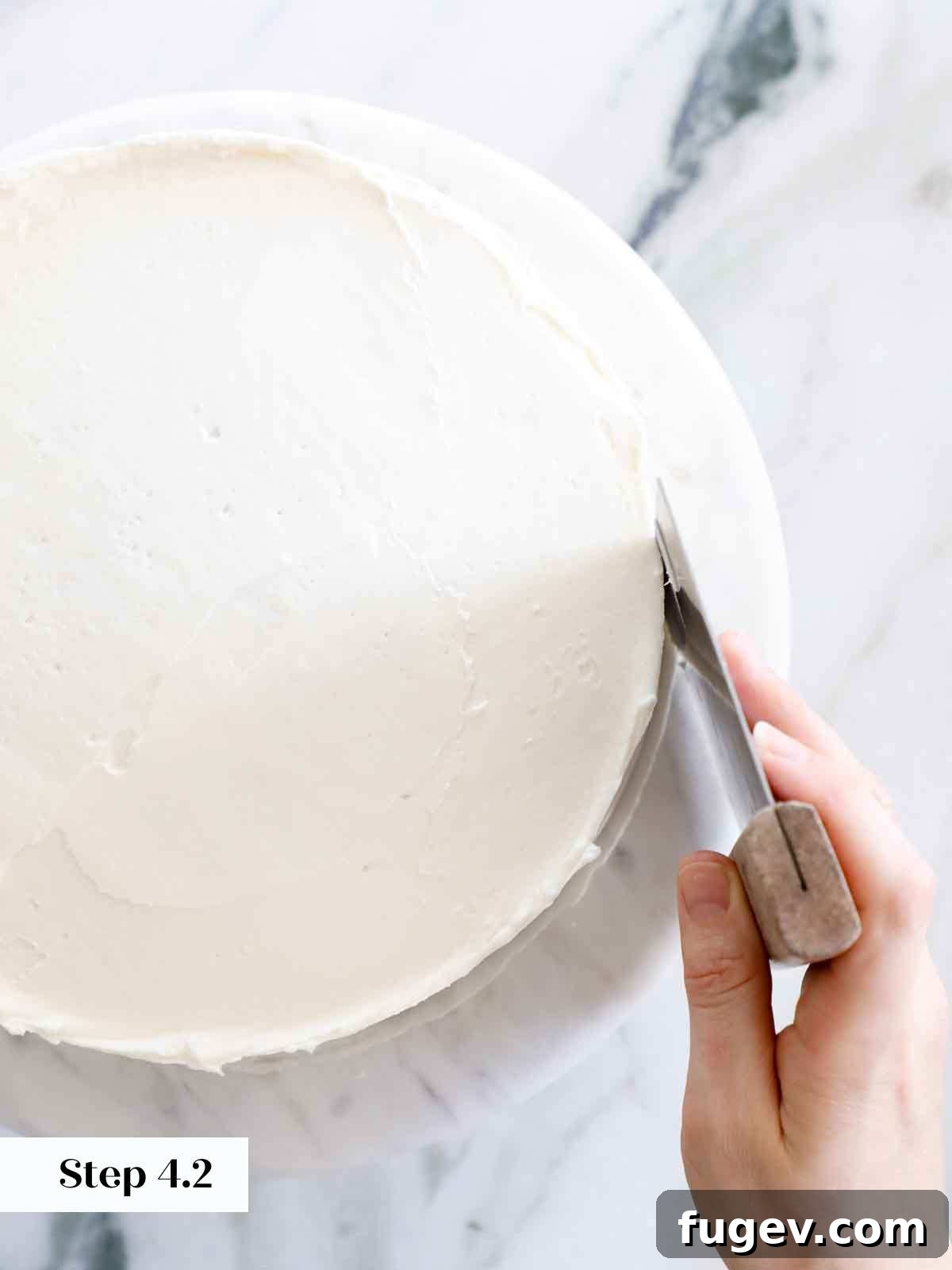 Velvet Vanilla Cake Recipe 24 Using a bench scraper to achieve perfectly smooth sides on a frosted cake.