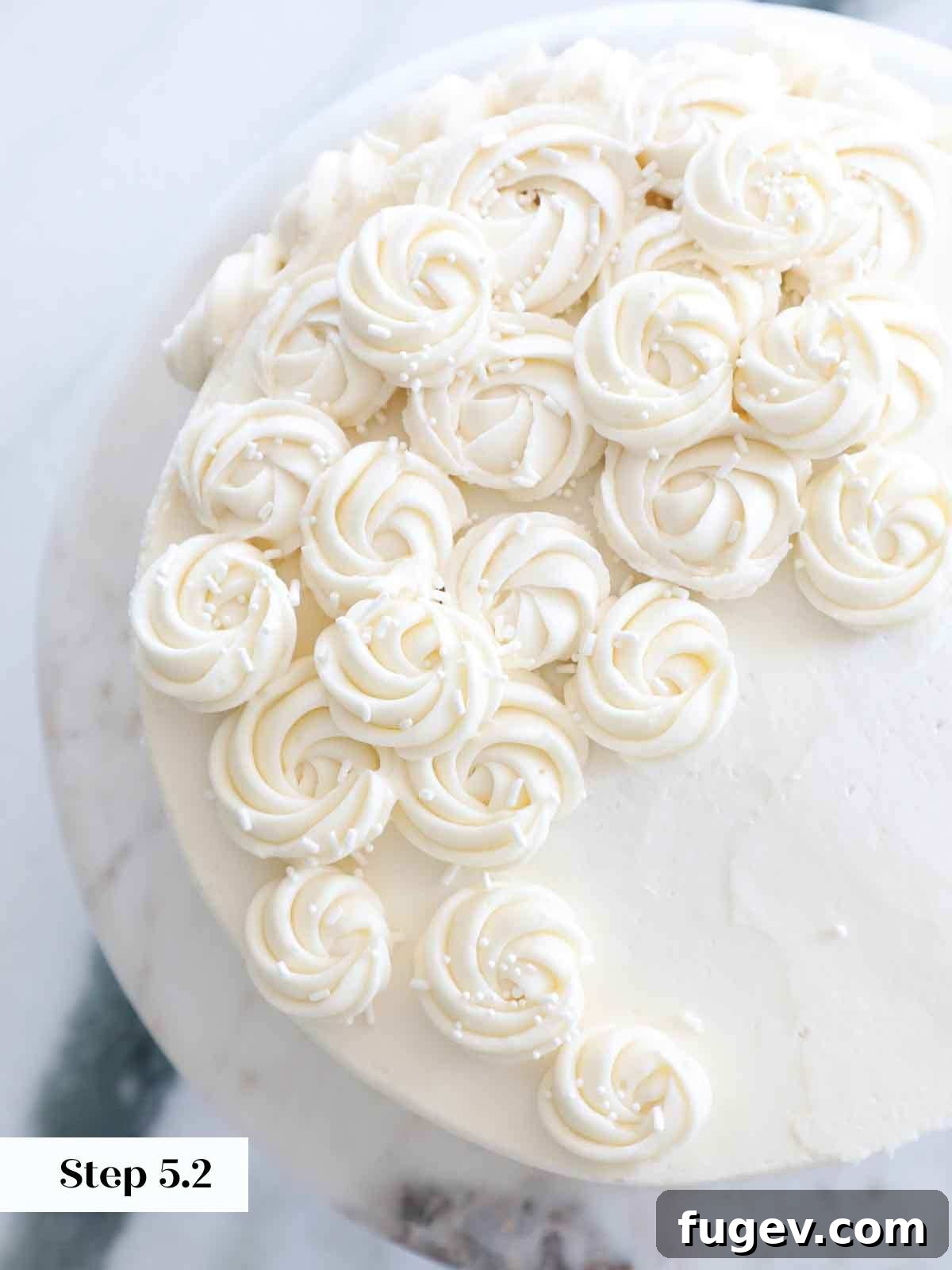 Velvet Vanilla Cake Recipe 27 Beautifully piped vanilla American buttercream rosettes adorning a cake.