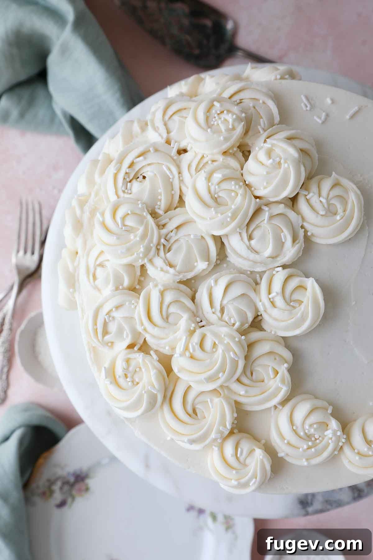 Velvet Vanilla Cake Recipe 4 A beautifully decorated multi-tier vanilla cake on a rustic tablescape, ready for celebration.