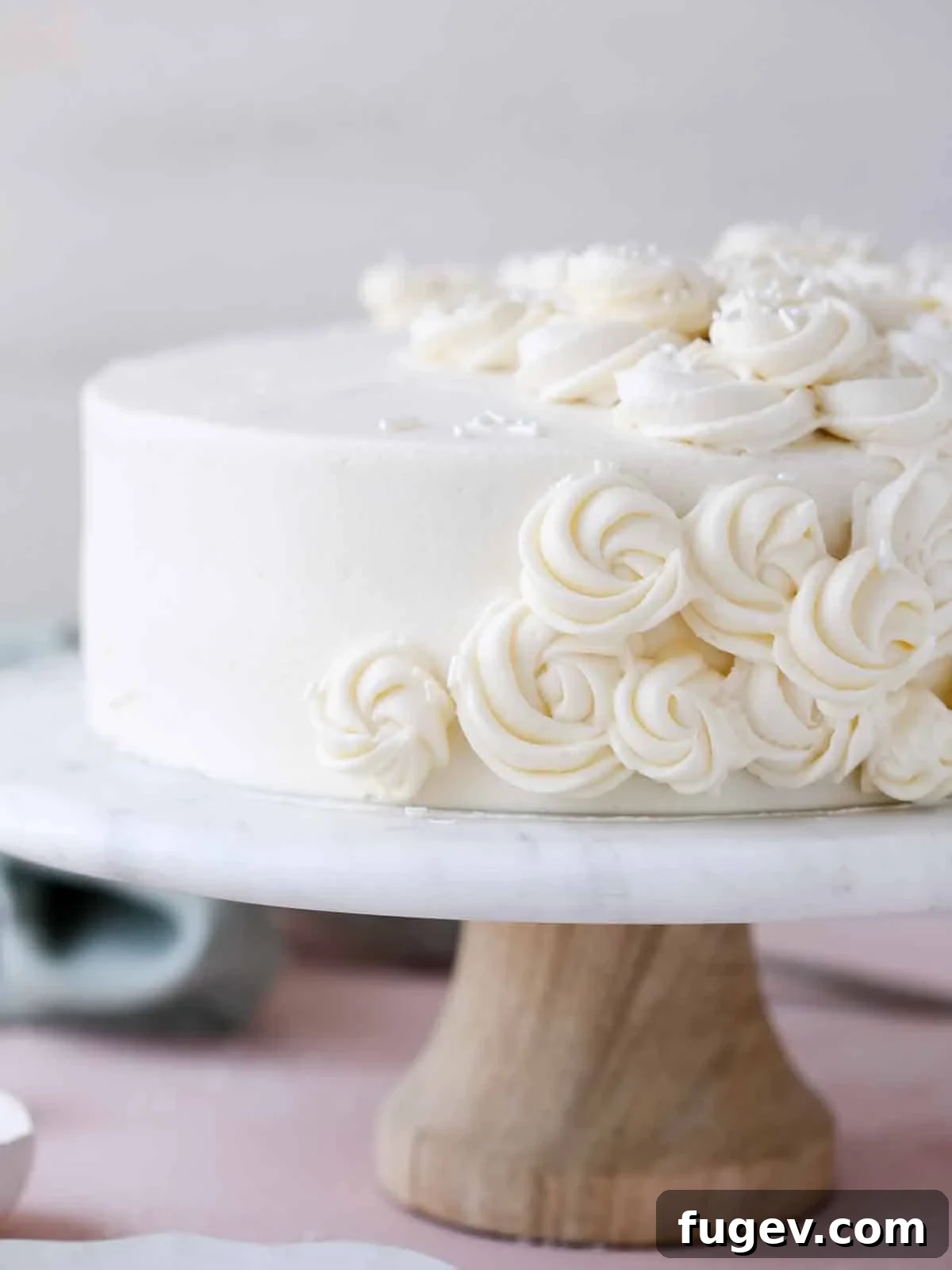 Velvet Vanilla Cake Recipe 7 A perfectly frosted moist vanilla cake presented on an elegant cake stand.