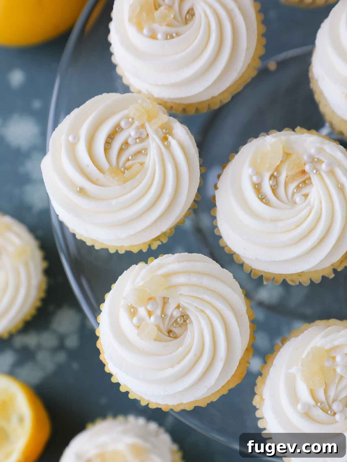 Zesty Lemon Delights 3 frosted lemon cupcakes on glass vintage cake stand.