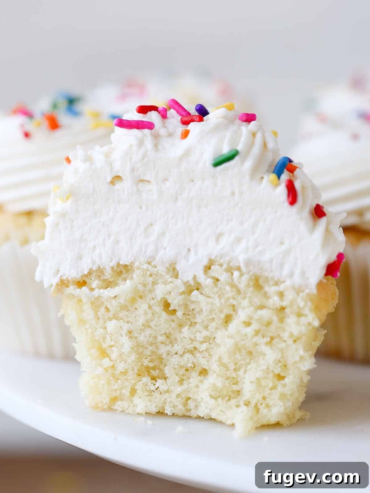 Silky Smooth Ermine Buttercream 2 Light, fluffy ermine frosting generously piped on a vanilla cupcake, showcasing its elegant texture and perfect peaks.