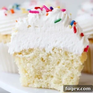 Silky Smooth Ermine Buttercream 16 Airy ermine frosting on a cupcake split in half, revealing its light interior.