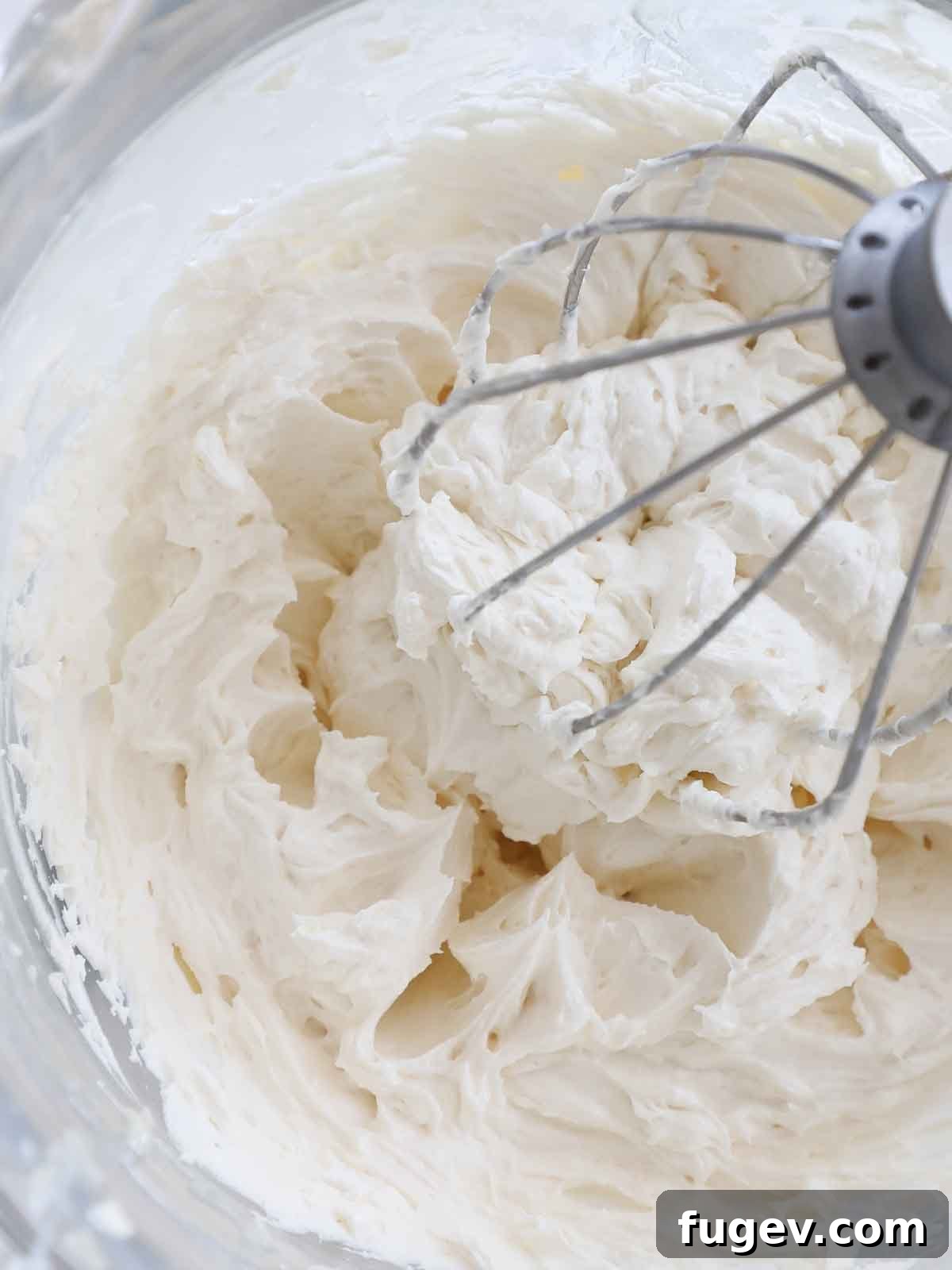 Silky Smooth Ermine Buttercream 3 Light and fluffy ermine frosting swirling beautifully in a mixing bowl with a whisk attachment, ready to be spread.
