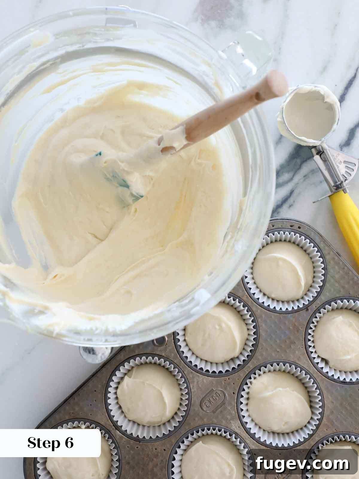 Golden Vanilla Bliss 9 Evenly portioned vanilla cake batter in cupcake liners, ready for baking.