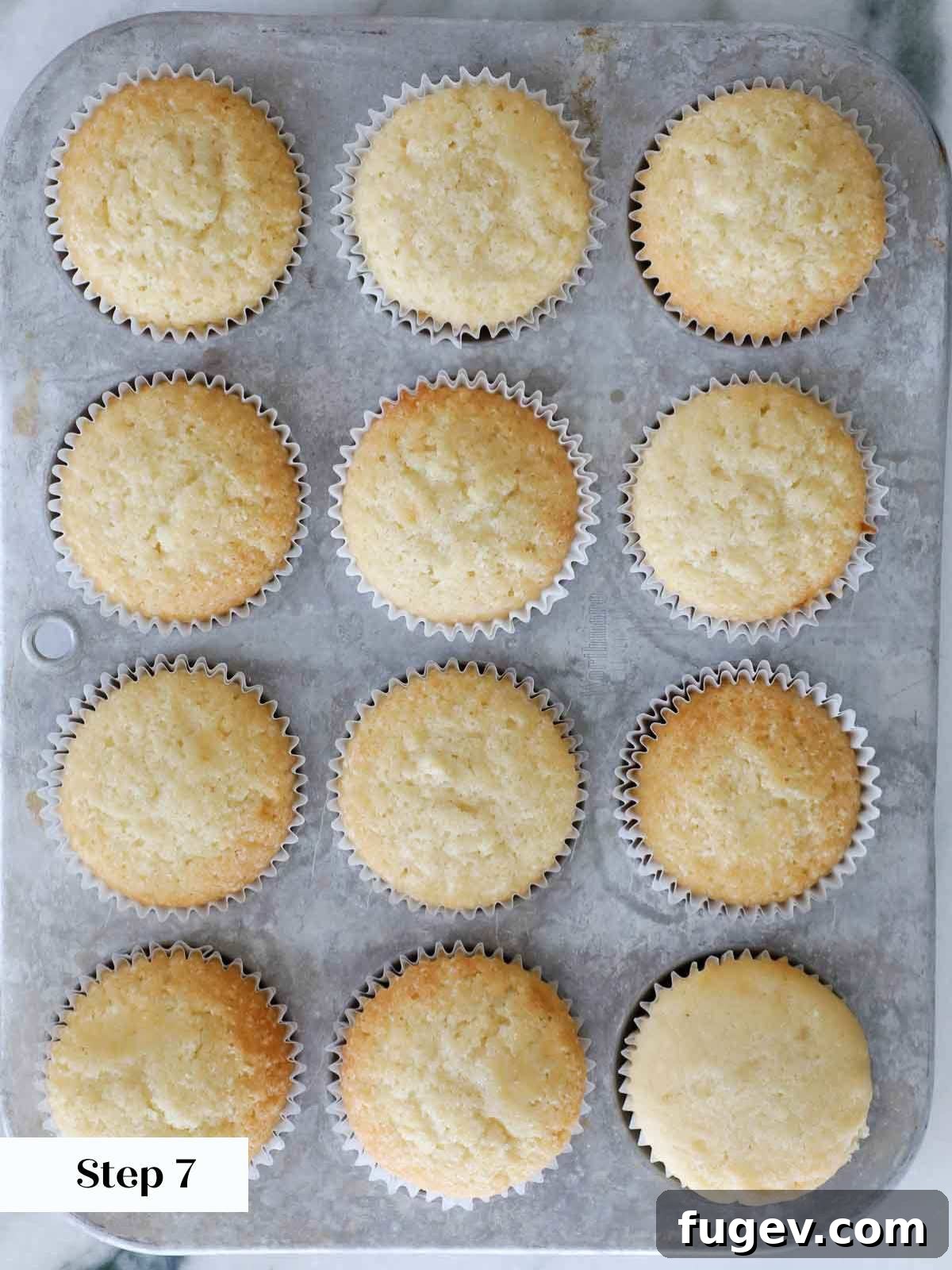 Golden Vanilla Bliss 10 Freshly baked vanilla cupcakes nestled in a metal tin, perfectly golden and risen.