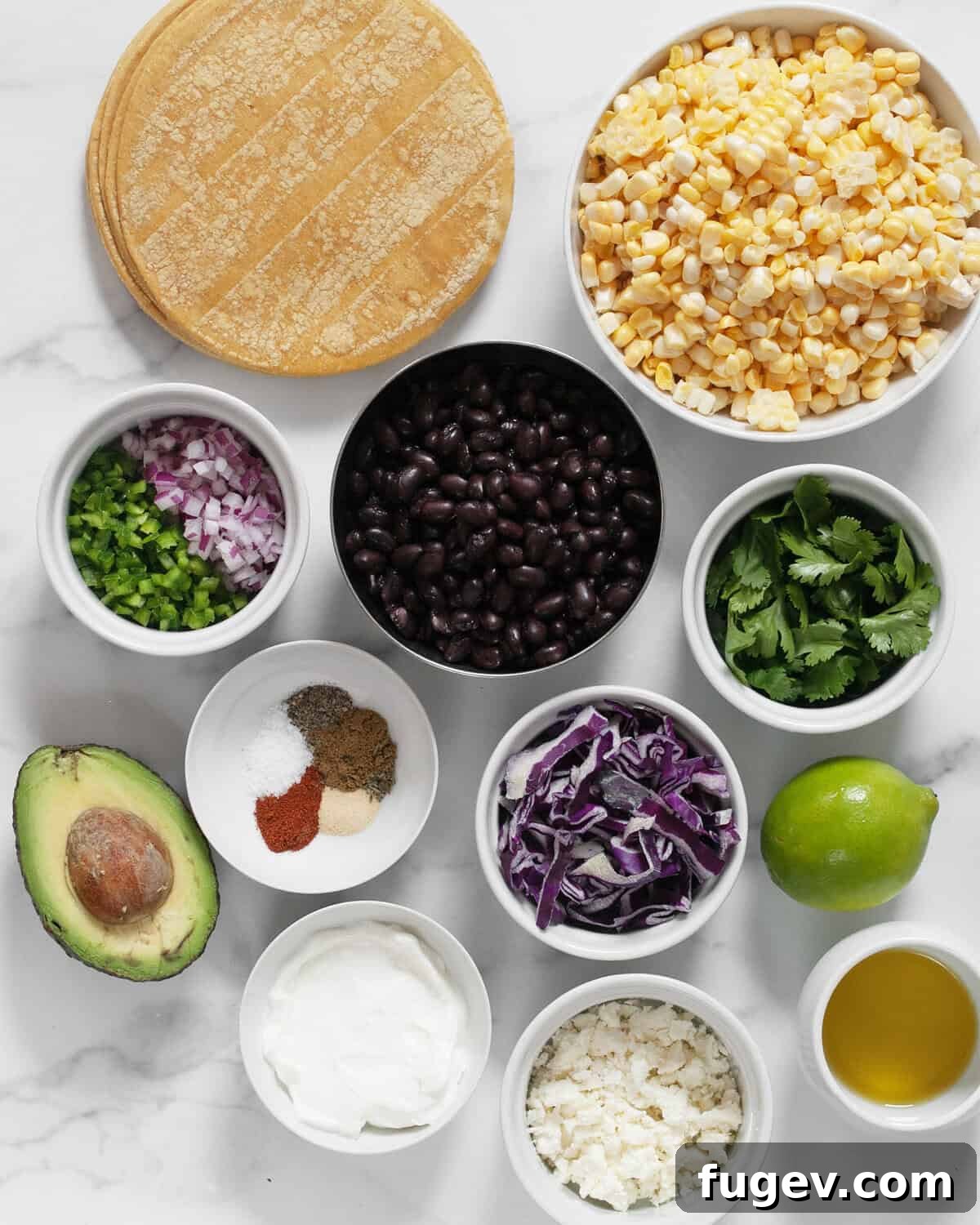 Ingredients including fresh corn, black beans, corn tortillas, cilantro, red onions, jalapenos, various spices, lime, feta cheese, Greek yogurt, avocado, and olive oil.