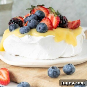 A perfect pavlova topped with a bright lemon fruit topping, ready to be served.