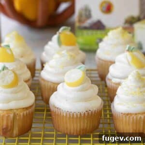 Lemon elderflower cupcakes topped with delicate candies, arranged artfully.