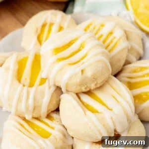 Stacked lemon curd thumbprint cookies, showcasing their golden edges and vibrant filling.