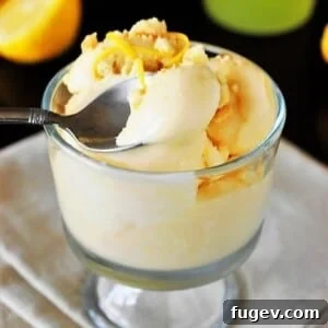 Limoncello Lemon Ice Cream served in a dish with a silver spoon resting nearby.