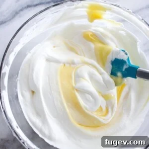 Lemon Whipped Cream with lemon curd being folded in, illustrating the process.