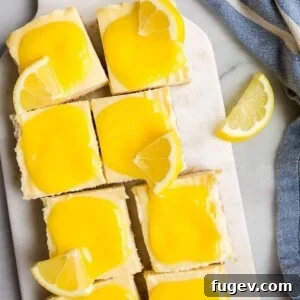 Lemon cheesecake bars adorned with a smooth lemon glaze, perfect for a small gathering.