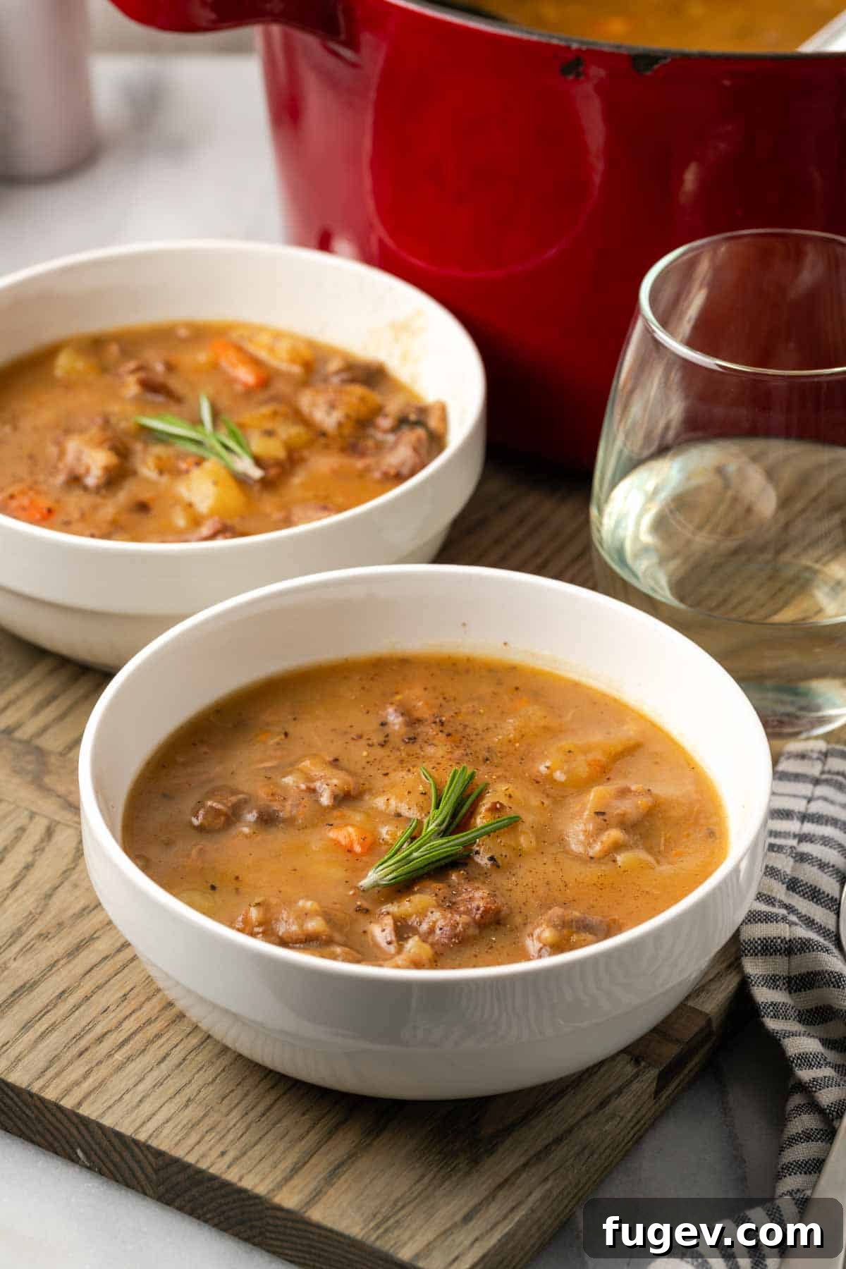 Hearty Lamb Stew 13 An inviting tablescape featuring a large bowl of hearty lamb stew, surrounded by rustic bread and fresh herbs, ready for a cozy meal.