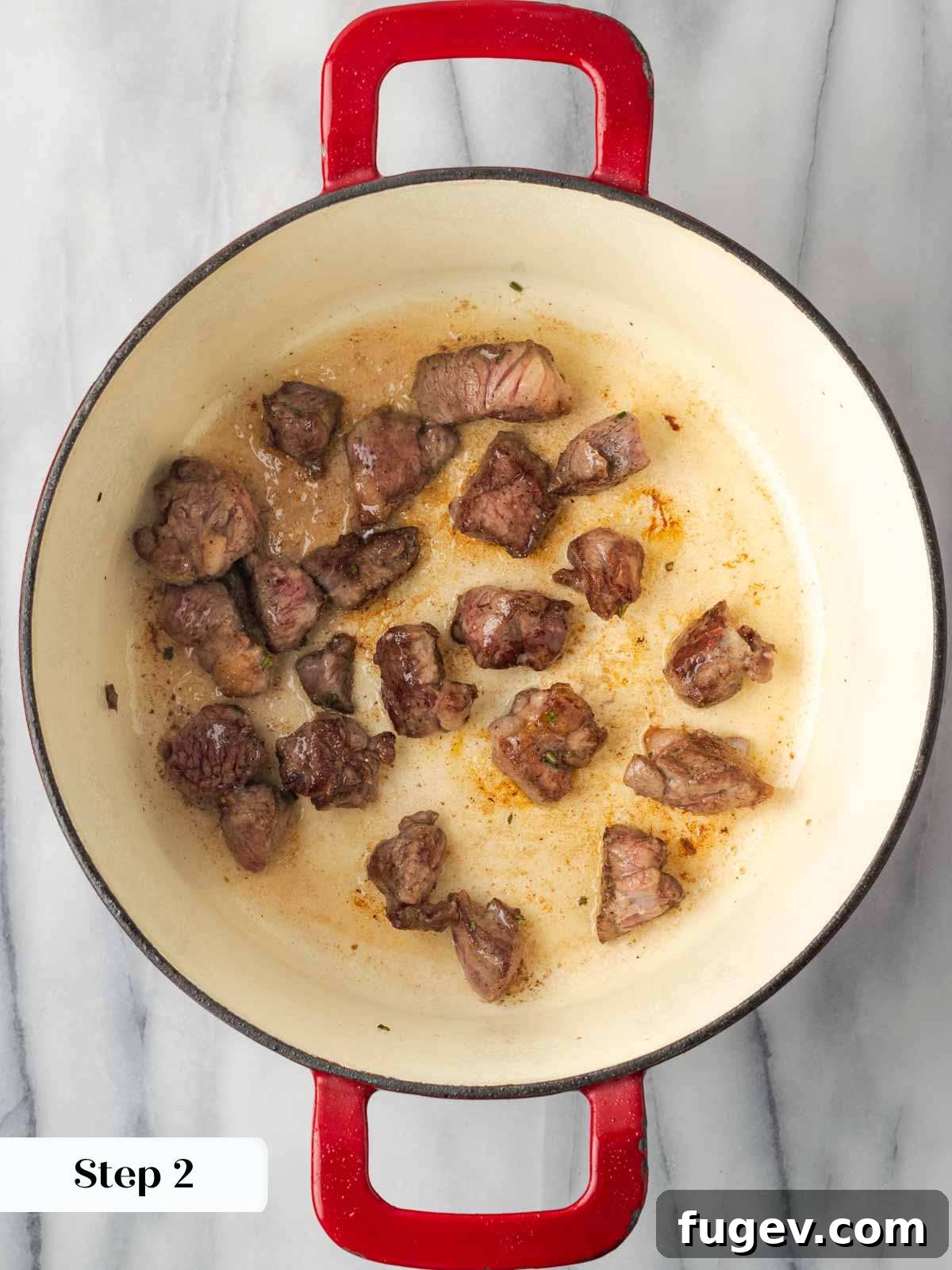 Hearty Lamb Stew 7 Lamb pieces searing in a hot Dutch oven, developing a rich brown crust.