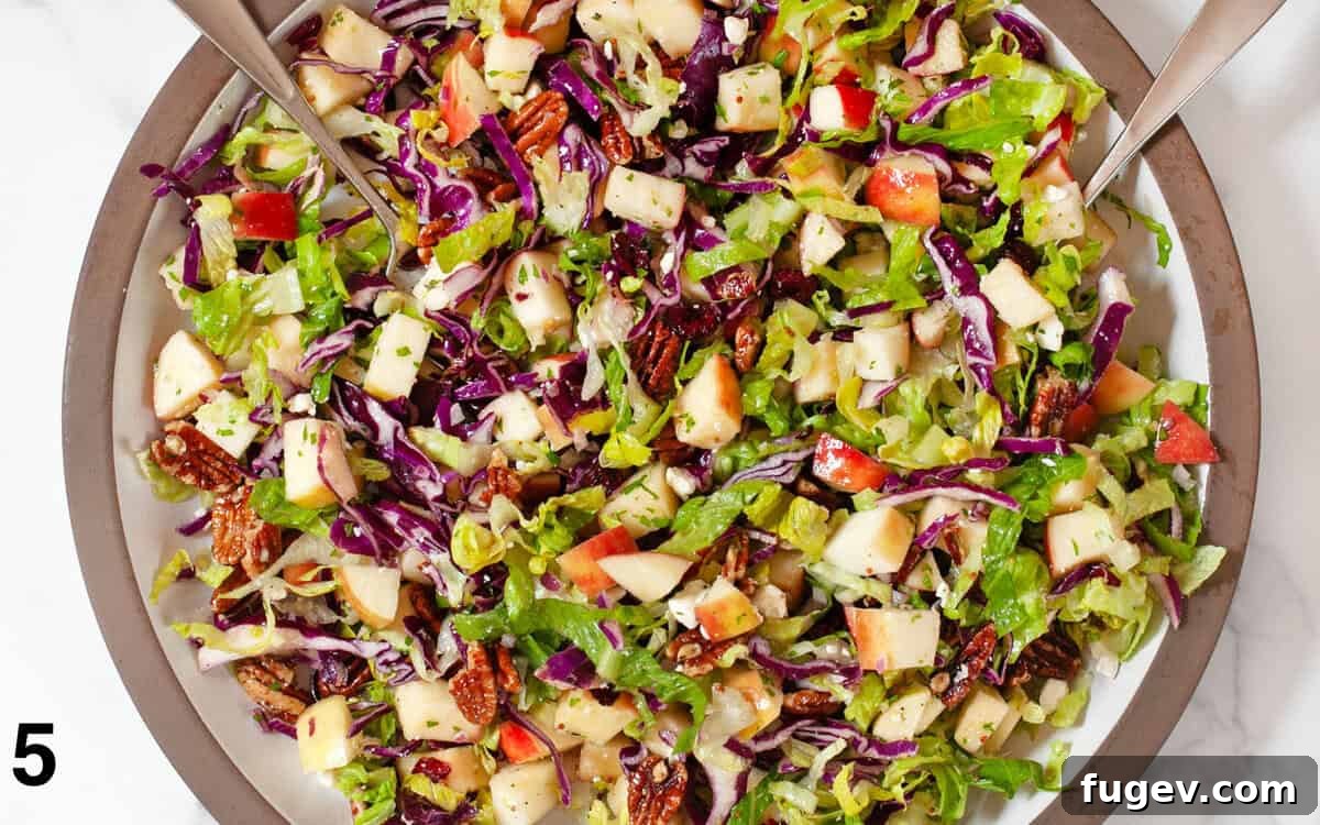 Crisp Apple Pecan Salad 6 Salad tossed with dressing in a large bowl.