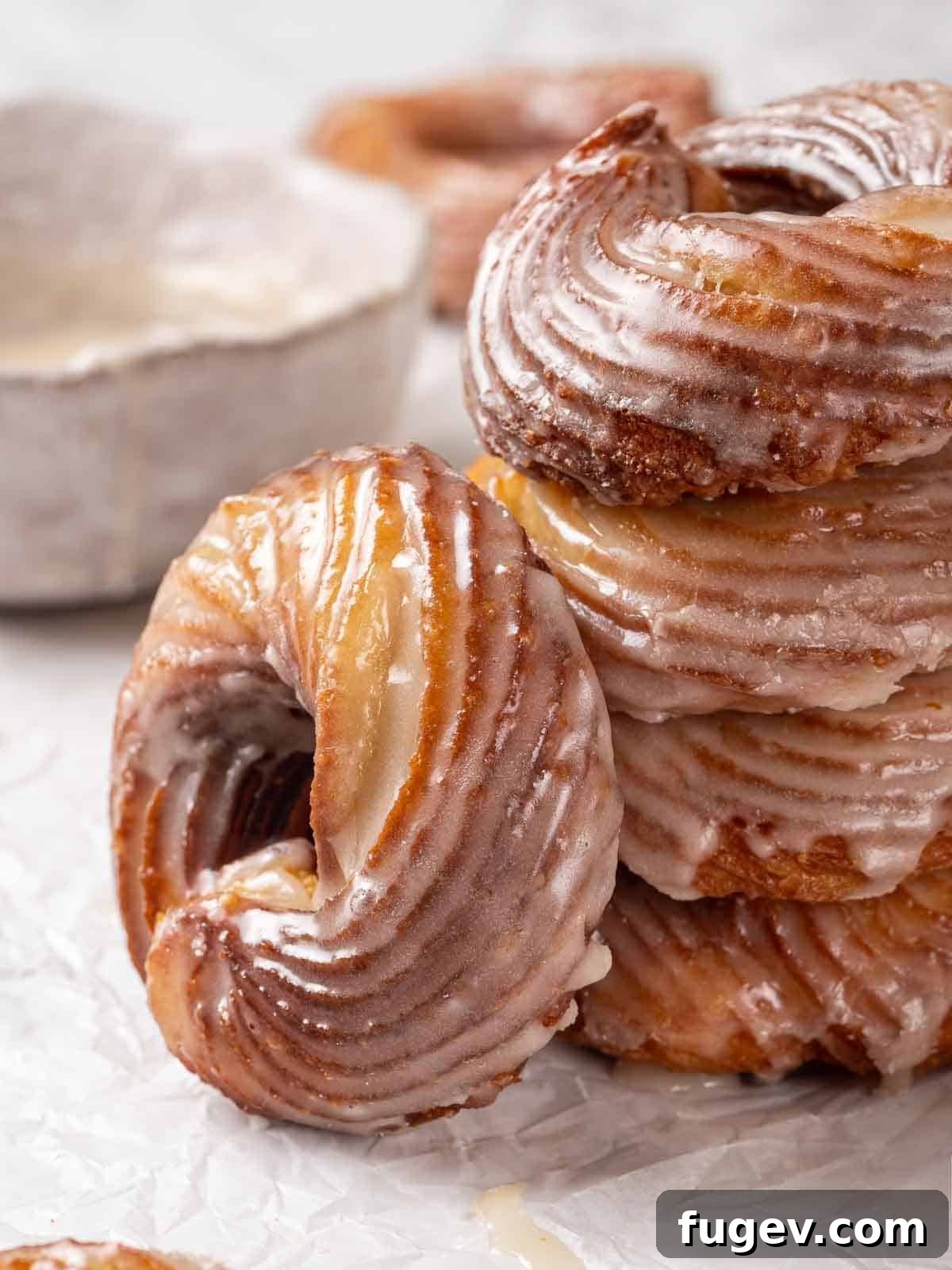 Elegant Choux Doughnuts 2 french crullers leaning against a stack of crullers.