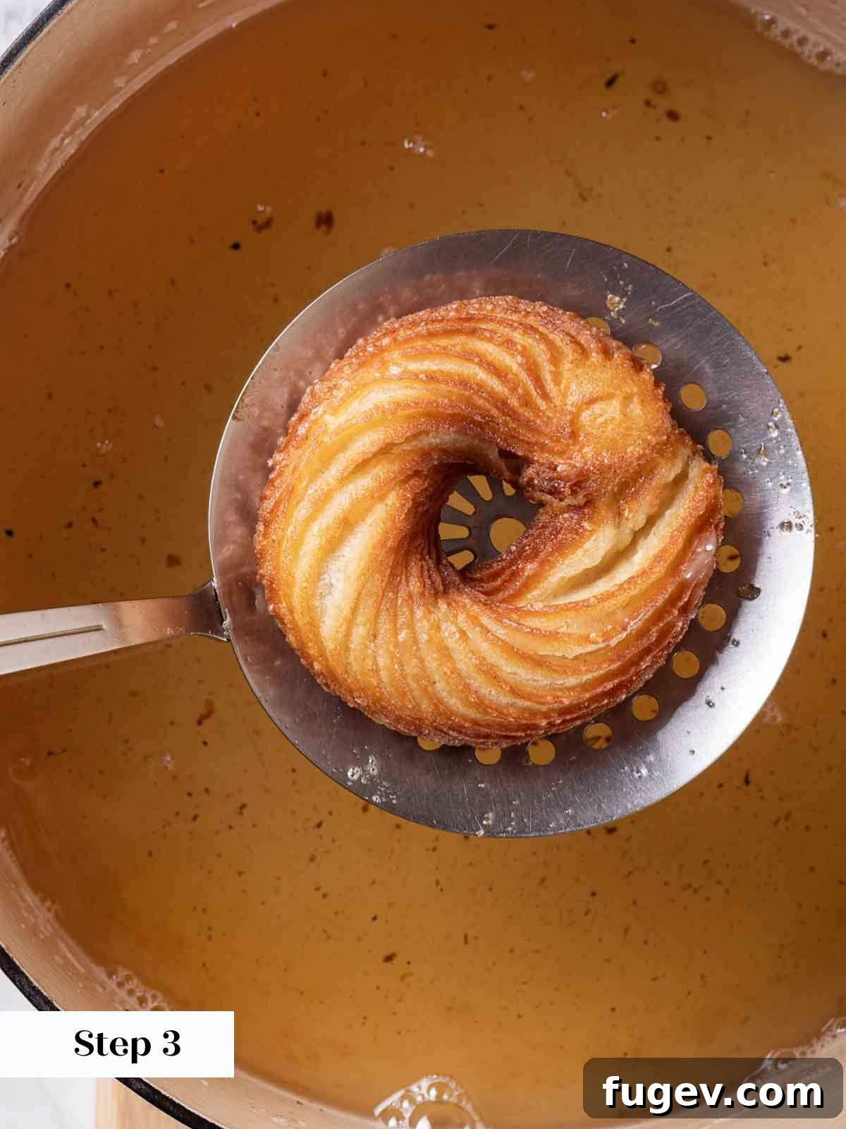 Elegant Choux Doughnuts 16 removing cruller from fryer oil with perforated spoon.
