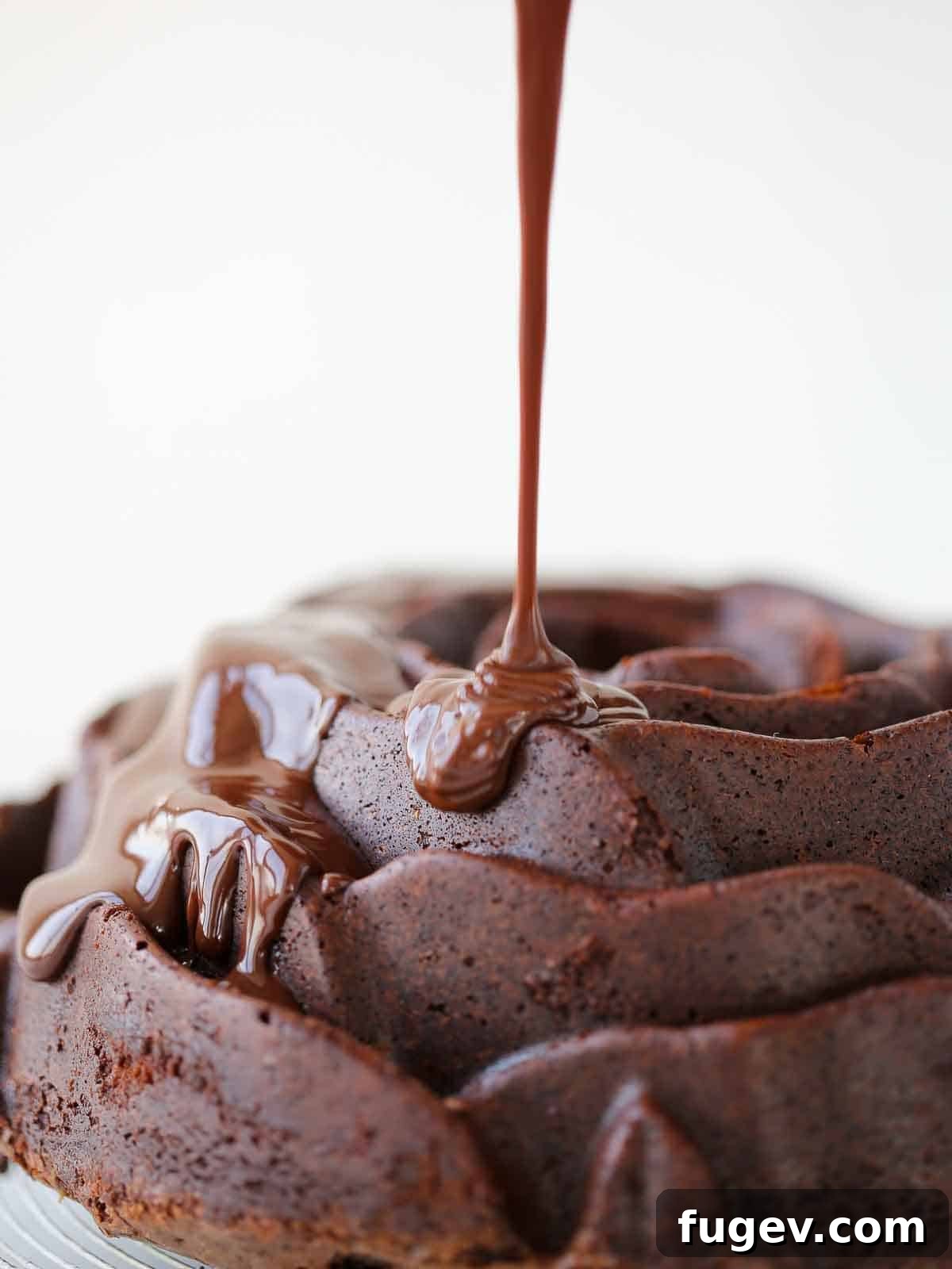 Mastering Chocolate Ganache 11 Decadent chocolate ganache gracefully pouring onto a luscious chocolate cake, creating a perfect glaze.