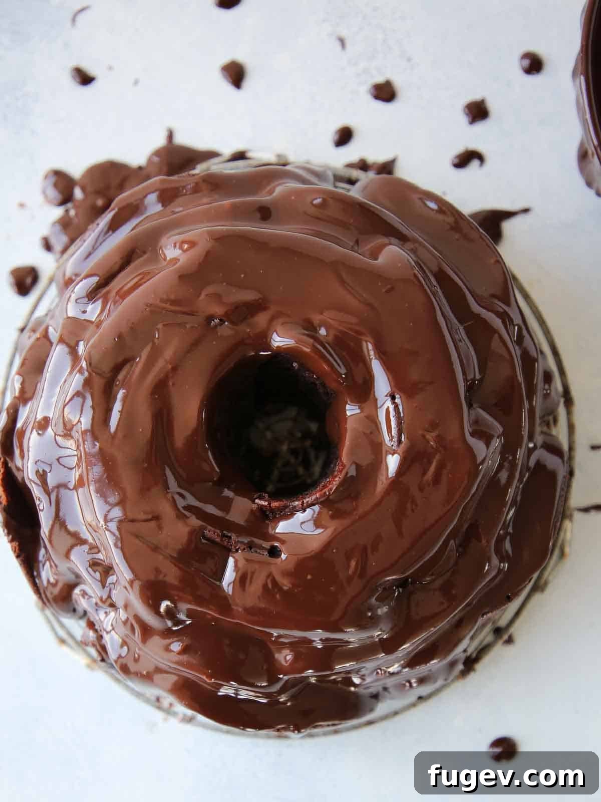 Mastering Chocolate Ganache 3 A stunning chocolate bundt cake generously covered in a glossy, rich chocolate ganache.