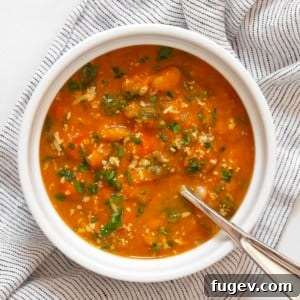 One bowl of creamy pumpkin soup with white beans and kale.