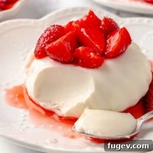 buttermilk panna cotta with strawberries bite on spoon.