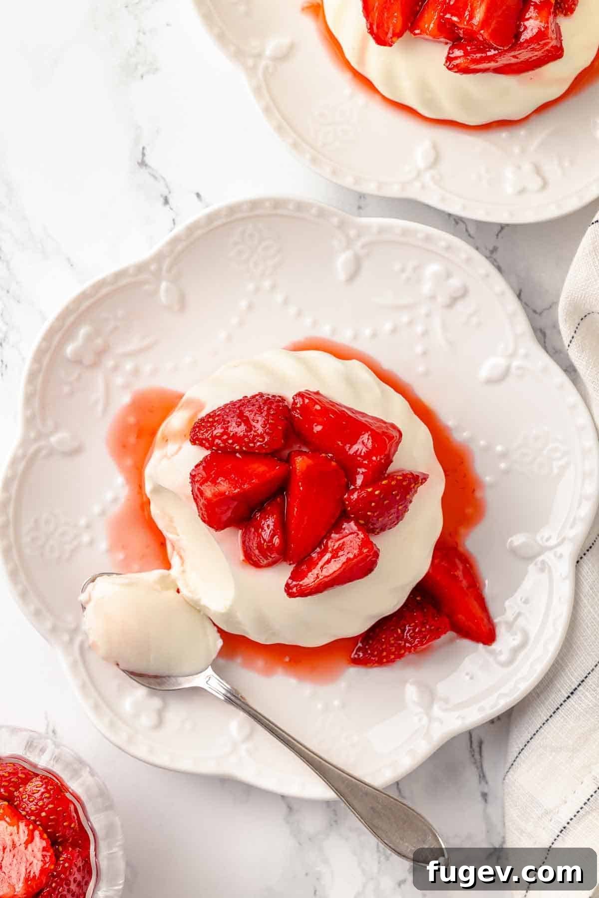 Tangy Buttermilk Panna Cotta 3 buttermilk panna cotta with macerated strawberries overhead.