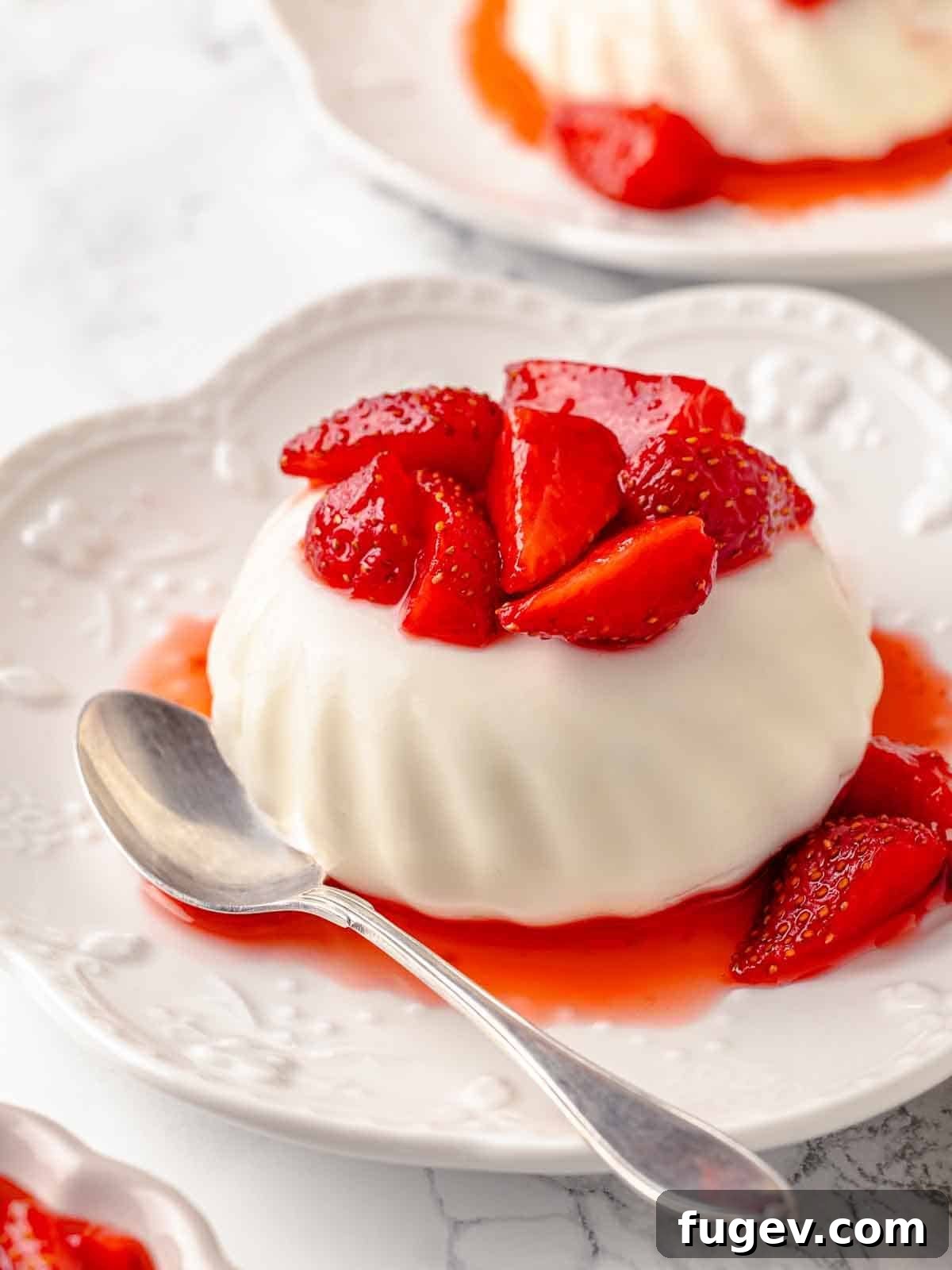 Tangy Buttermilk Panna Cotta 5 unmolded buttermilk panna cotta with strawberries.