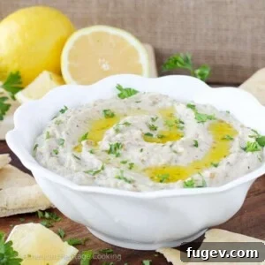 Authentic homemade Baba Ganoush garnished with a fresh herb and a swirl of olive oil.