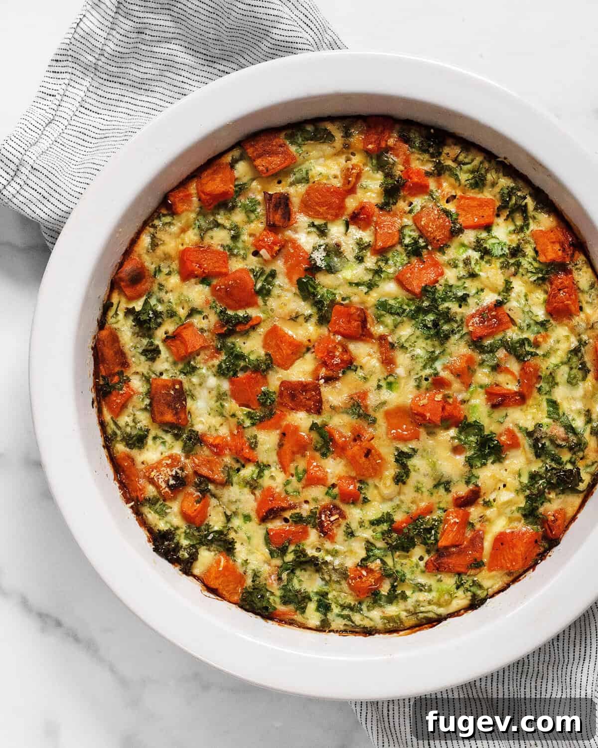 A beautifully golden-brown roasted sweet potato cottage cheese egg bake in a rustic pie dish, ready to be served.