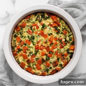 A freshly baked roasted sweet potato egg bake in a pie dish, with a golden-brown top and visible ingredients.